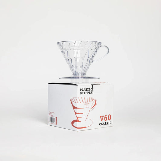 Clear glass coffee dripper on a white box with 'V60 Classic' branding on a white background