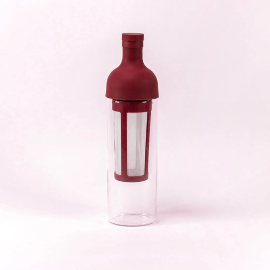 Bottle-shaped container with maroon top and clear body on a white background